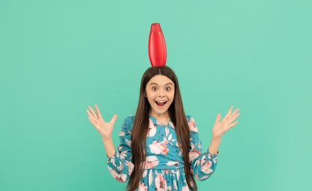 surprised kid with long hair hold shampoo bottle, hairdresserの写真素材
