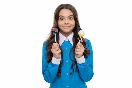 happy girl isolated on white. amazed child with chocolate. kid with long curly hair hold stick sweetの写真素材