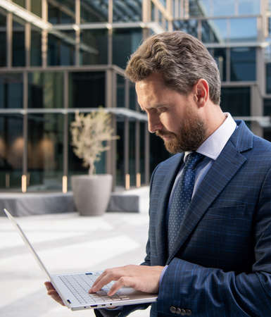 successful bearded businessman in formal suit working online on computer, internetの写真素材