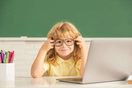september 1. e-learning. child studying on computer. happy teen boy in classroom.