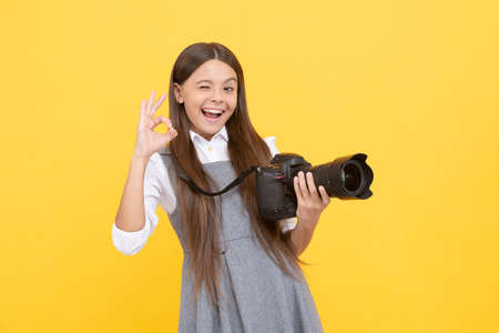 cheerful kid girl take photo with digicam show ok gesture, photographyの写真素材