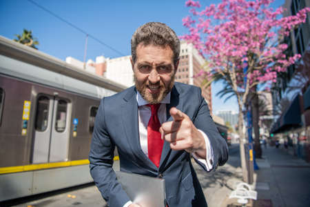 angry businessman with laptop for blogging. social network and weblog. agile business.の写真素材