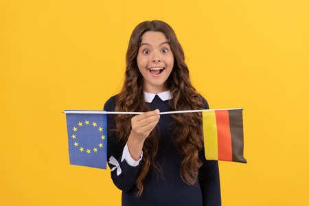 amazed child holding european union and german flag. touristic visa in schengen countryの写真素材
