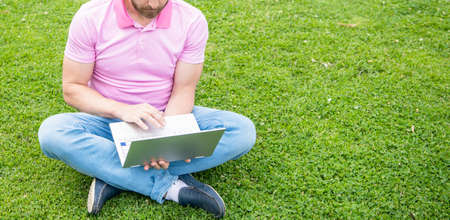 cropped freelance man post blog online sit on grass, copy space, agile businessの写真素材