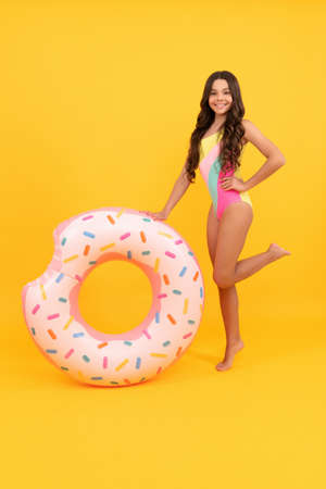 cheerful girl in swimsuit inflatable doughnut ring. teen with swimming ring.の写真素材