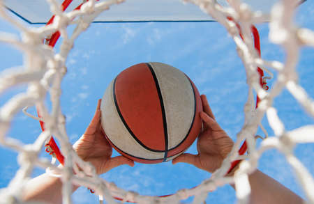 basketball ball flying through basket in players hands, sportの写真素材