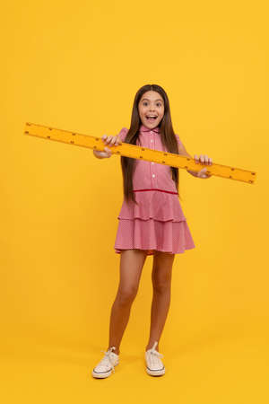 amazed teen girl hold ruler. back to school. algebra and geometry. kid study math.の写真素材