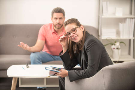man sitting at psychologist woman solving problem, therapyの写真素材