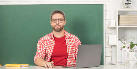 nerd student study online. private teacher in classroom with blackboard at pc.の写真素材