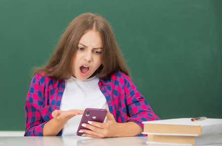 shocked child typing and texting. sms and instant messaging.の写真素材