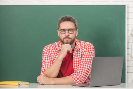 teachers day. tutor man in glasses with laptop. adult student study online.の写真素材