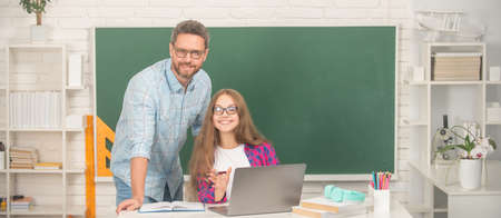 private teacher and child at computer. family help. dad and daughter near clackboard.の写真素材