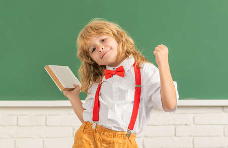 nerd kid with long hair at blackboard. september 1. childhood development.の写真素材