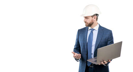 Serious engineer man in hardhat and suit use laptop computer for constructing, engineeringの写真素材