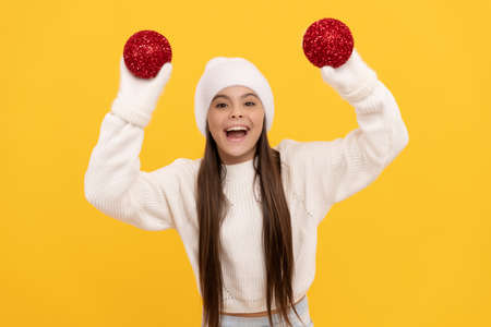 amazed teen girl ion winter hat and gloves hold decorative new year balls, new year.の写真素材