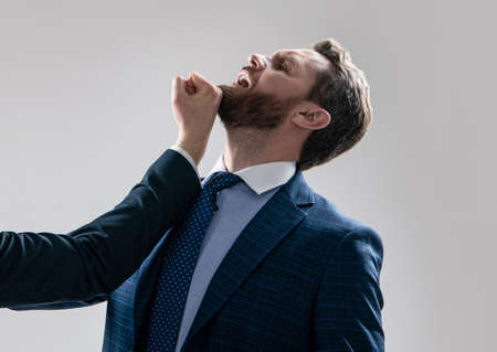 Professional man manager in suit got blow jaw punch fisticuff, workplace violence.の写真素材