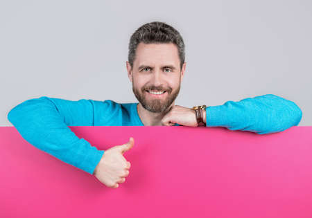 presenting novelty information. male behind pink paper show thumb up.の写真素材