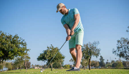 male golf player on professional golf course. portrait of golfer in cap with golf club.