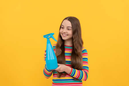 Happy kid hold disinfectant spraying bottle for copy space yellow background, sprayの写真素材