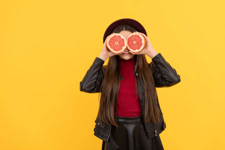 look here. happy girl in leather hold grapefruit. stylish teen child. vitamin dieting.の写真素材