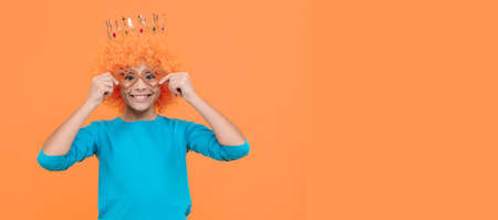 cheerful selfish child girl in wig and princess diadem wear party glasses, copy space, party fun.の写真素材