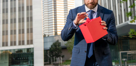 entrepreneur hold birthday gift. shopping concept. mens day. cropped businessman open box.