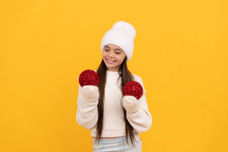 happy new year. cheerful child in winter hat and gloves. kid with decorative ballsの写真素材