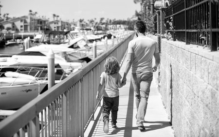 Father man and boy child promenade holding hands summer outdoors, family vacationの写真素材
