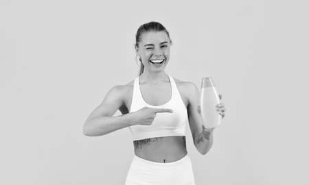 happy girl pointing finger on bottle of hair shampoo conditioner for skin care and bath, skincareの写真素材