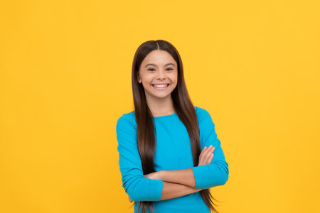 pretty look of young girl. face portrait of child on yellow background. express positive emotions.の写真素材