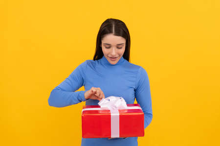 curious young lady open holiday present or gift box, shoppingの写真素材