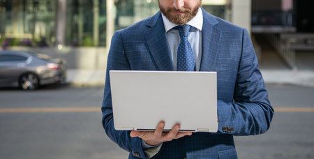 cropped entrepreneur in businesslike suit work on pc outside the office, networkingの写真素材