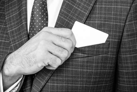 Business card being pulled out of formal suit pocket, contact info for copy spaceの写真素材