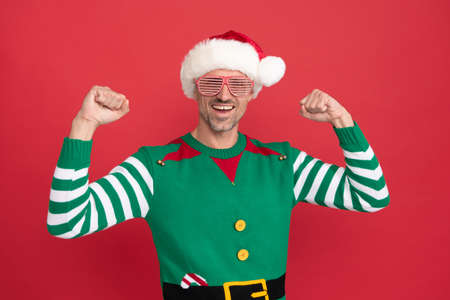 happy successful man in elf costume and party glasses. xmas guy in santa claus hat