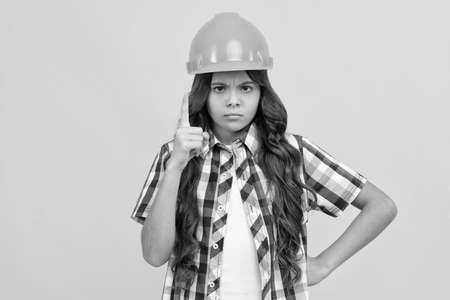 strict teen girl with curly hair in construction helmet, expertの写真素材