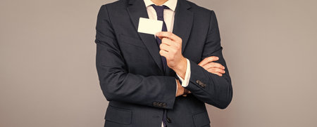 cropped man in suit showing business card with copy space, contact meの写真素材