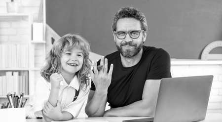 daddy and son study in classroom with laptop, online educationの写真素材