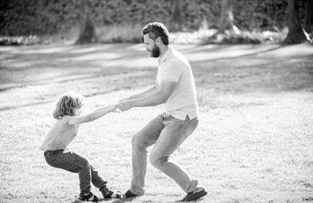 Happy boy child pull fathers hands playing on summer outdoors, playの写真素材