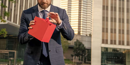entrepreneur hold birthday gift. shopping concept. mens day. cropped businessman open box.の写真素材