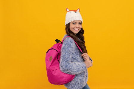 portrait of child wearing warm clothes carry backpack. express positive emotion.の写真素材
