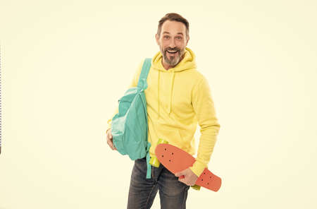happy mature man hipster in hoody with backpack and penny board isolated on white, skateboarding.