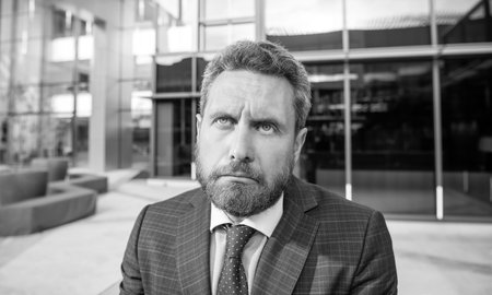 confused face of entrepreneur in businesslike suit outside the office, sadnessの写真素材