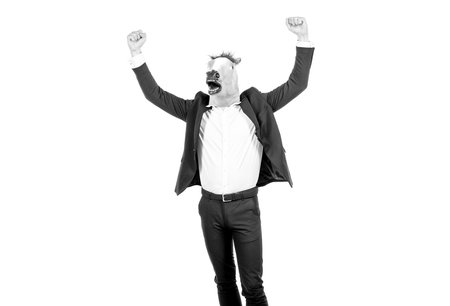 Hard work spells success. Businessman wear horse head mask with raised arms. Enjoying successの写真素材
