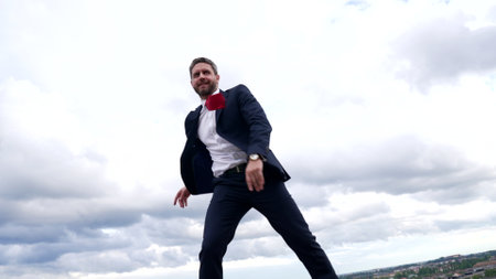 Successful professional employee man in formal suit dance in cloudy sky, dancingの写真素材