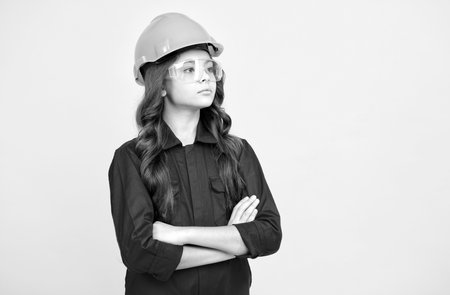 serious teenager girl in protective eyeglasses and helmet, copy space, buildingの写真素材