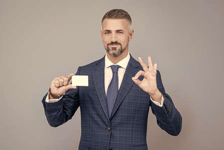 all is perfect. businessman demonstrating credit or debit card. empty plastic business name card.