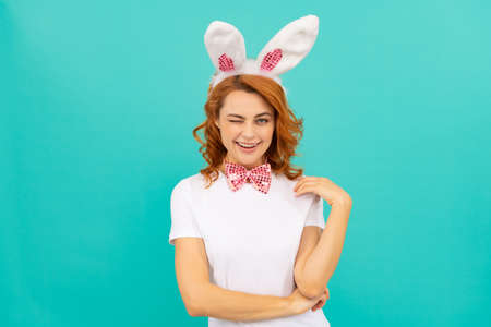 happy winking easter girl in bunny ears and bow tie on blue backgroundの写真素材