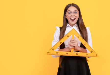 amazed teen girl hold triangle. back to school. algebra and geometry. kid glasses study math