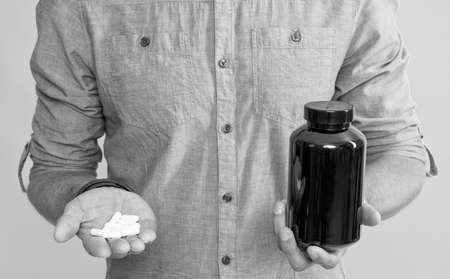 cropped guy holding drug jar on yellow background, healthcare