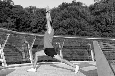 Feel the stretch in your hip. Man do crescent lunge stretch raising arms. Doing yoga or pilates...